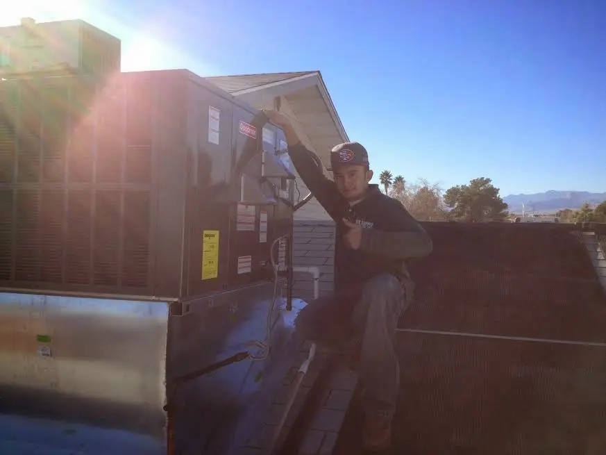 HVAC technician performing AC Tune-Up on a rooftop unit in Independence